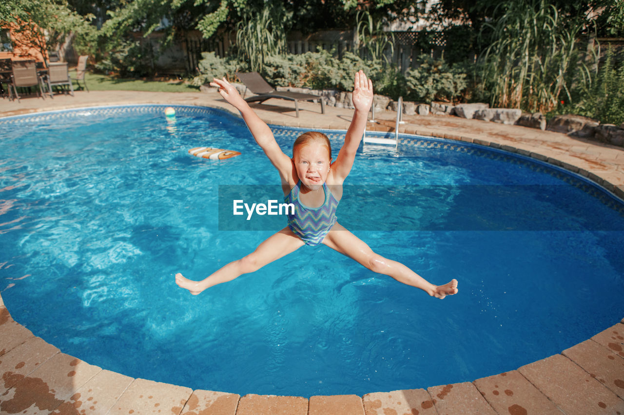 Girl jumping in swimming pool