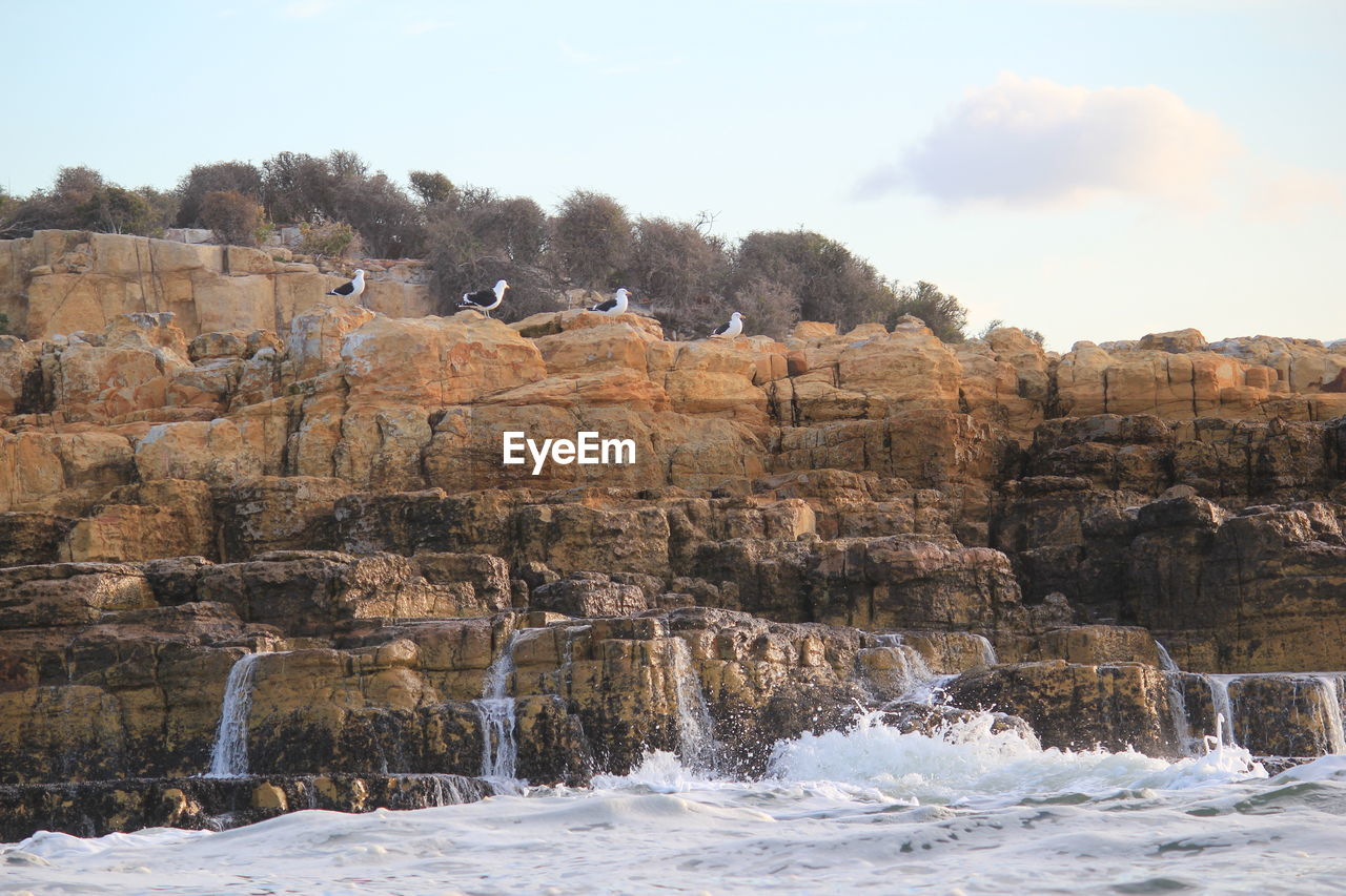 Scenic view of rocks and water against sky