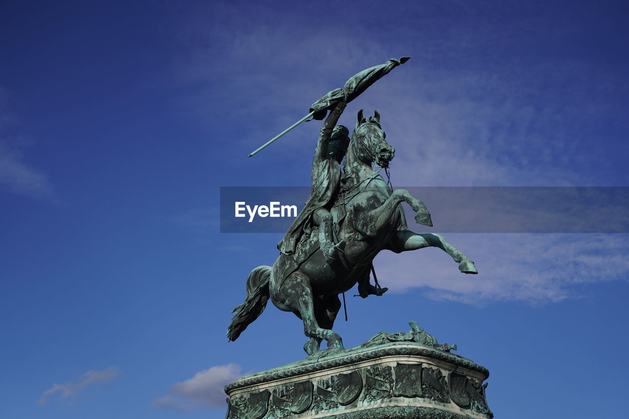 Low angle view of statue against blue sky