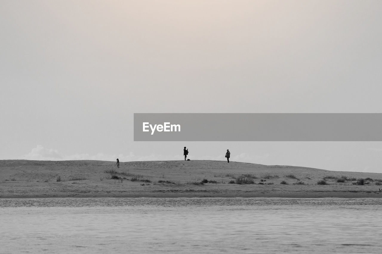 PEOPLE ON DESERT AGAINST SKY