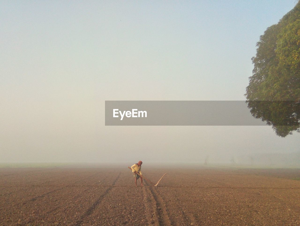 A farmer prepares the field for growing crops on a winter morning.