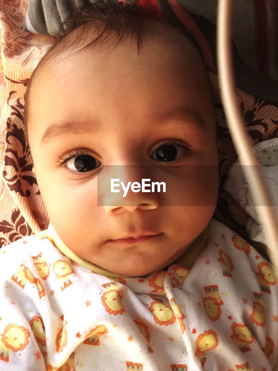 CLOSE-UP PORTRAIT OF CUTE BABY LYING ON BED