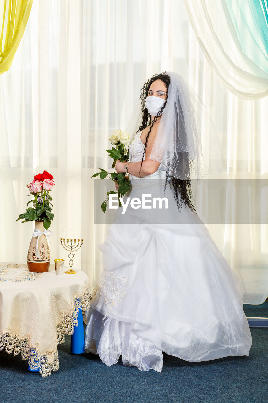 Woman wearing mask against white background