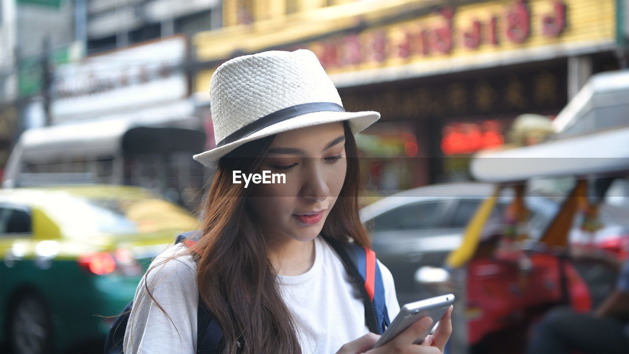 Young woman looking away while using mobile phone