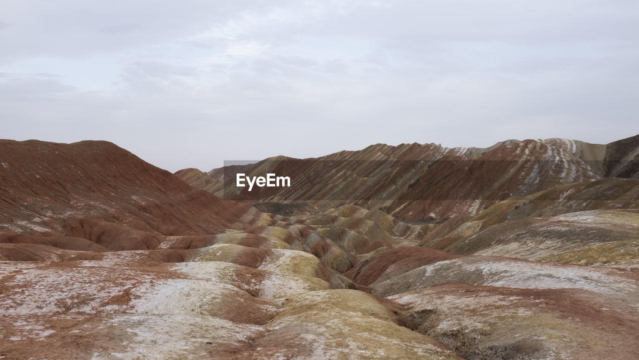 Scenic view of mountain against cloudy sky - danxia landform in northwest china