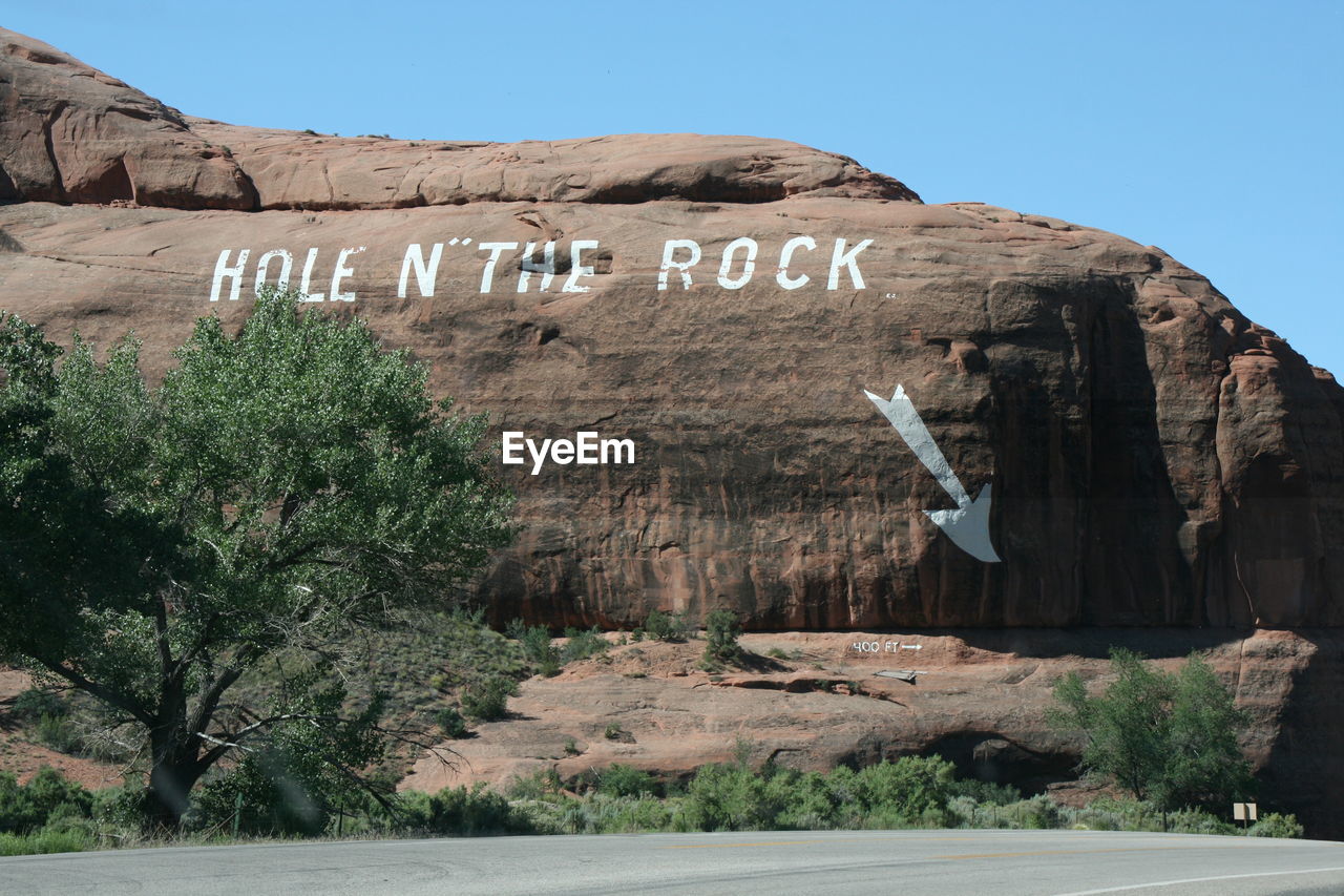Text on rock formation against sky