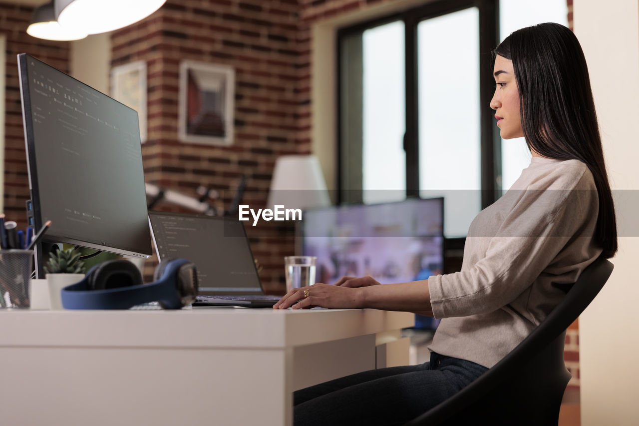 side view of woman using laptop on table