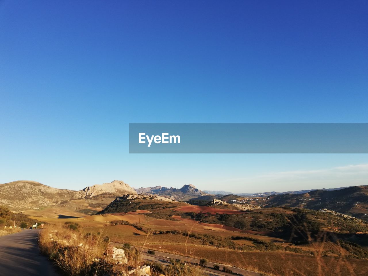 Scenic view of desert against clear blue sky