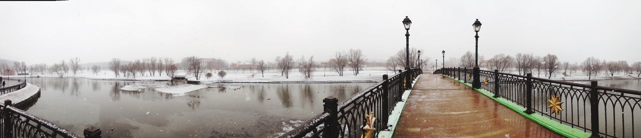 Panoramic view of frozen canal against clear sky