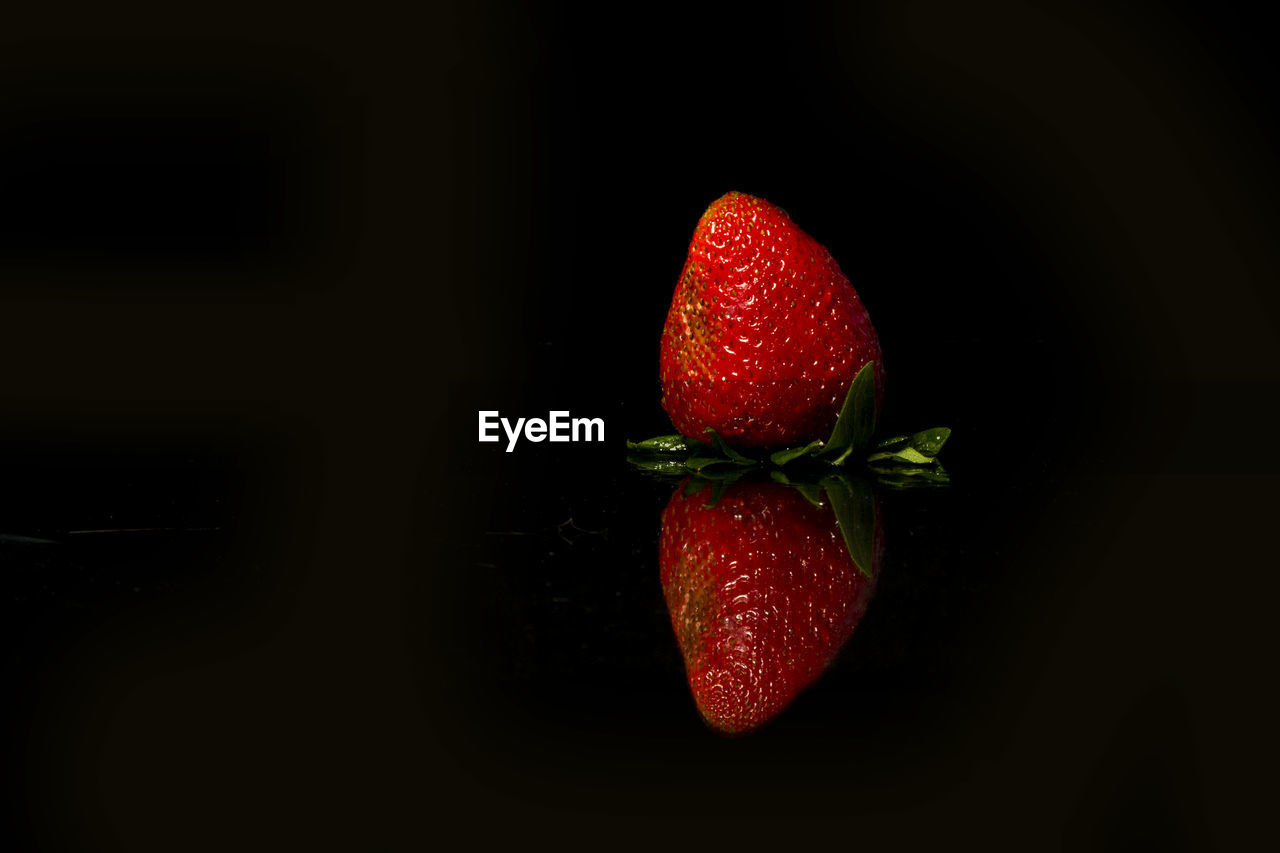 CLOSE-UP OF STRAWBERRIES IN BLACK BACKGROUND
