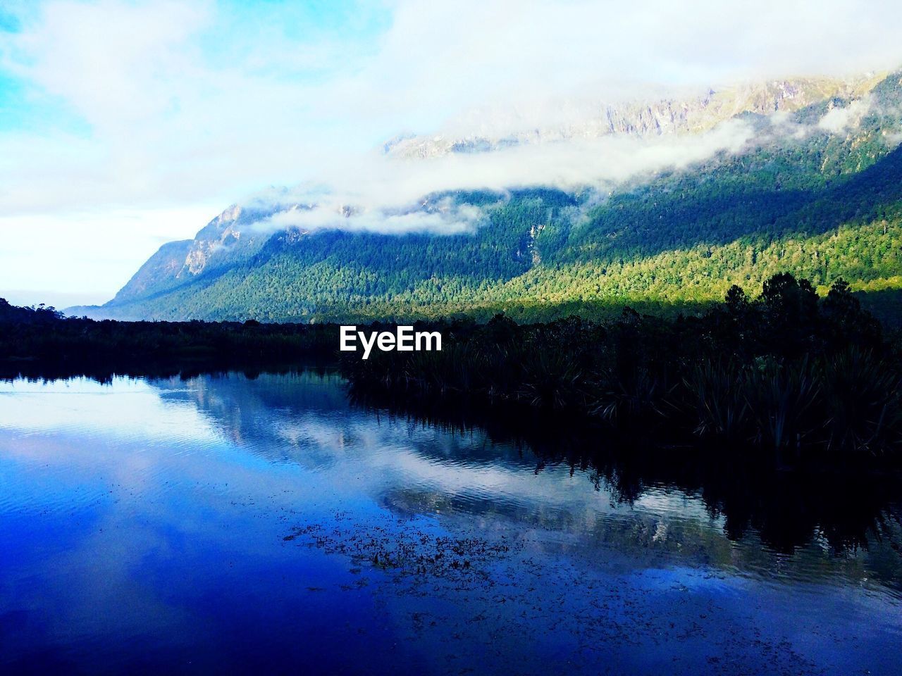 SCENIC VIEW OF LAKE BY MOUNTAIN AGAINST SKY