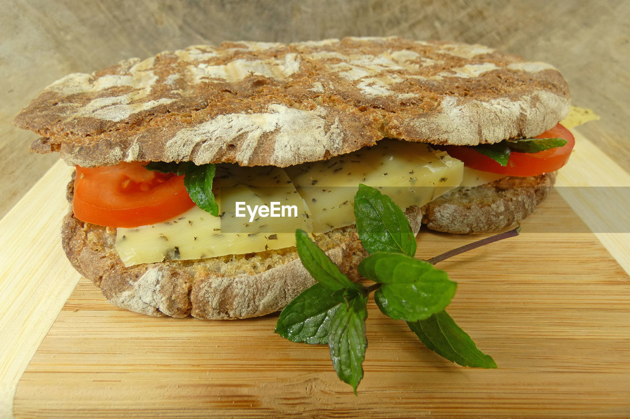 High angle view of fresh bread roll with cheese on table