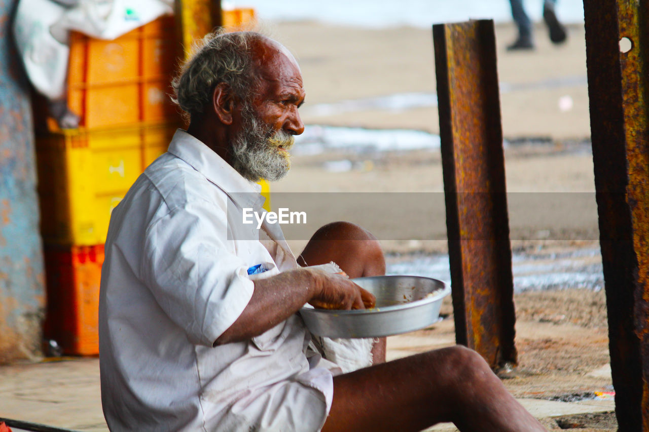 Man eating food while sitting outdoors