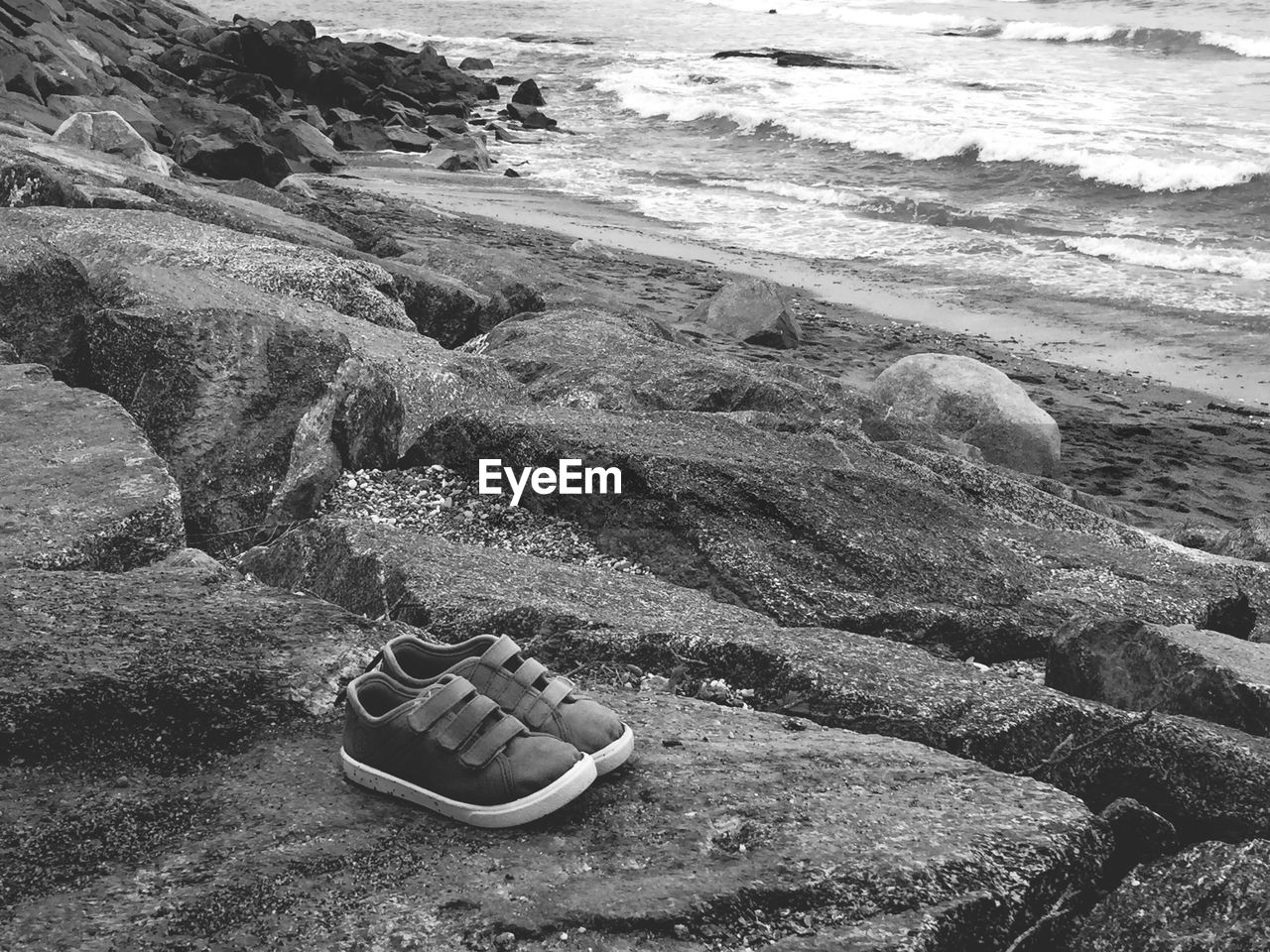 Shoes on rock by sea