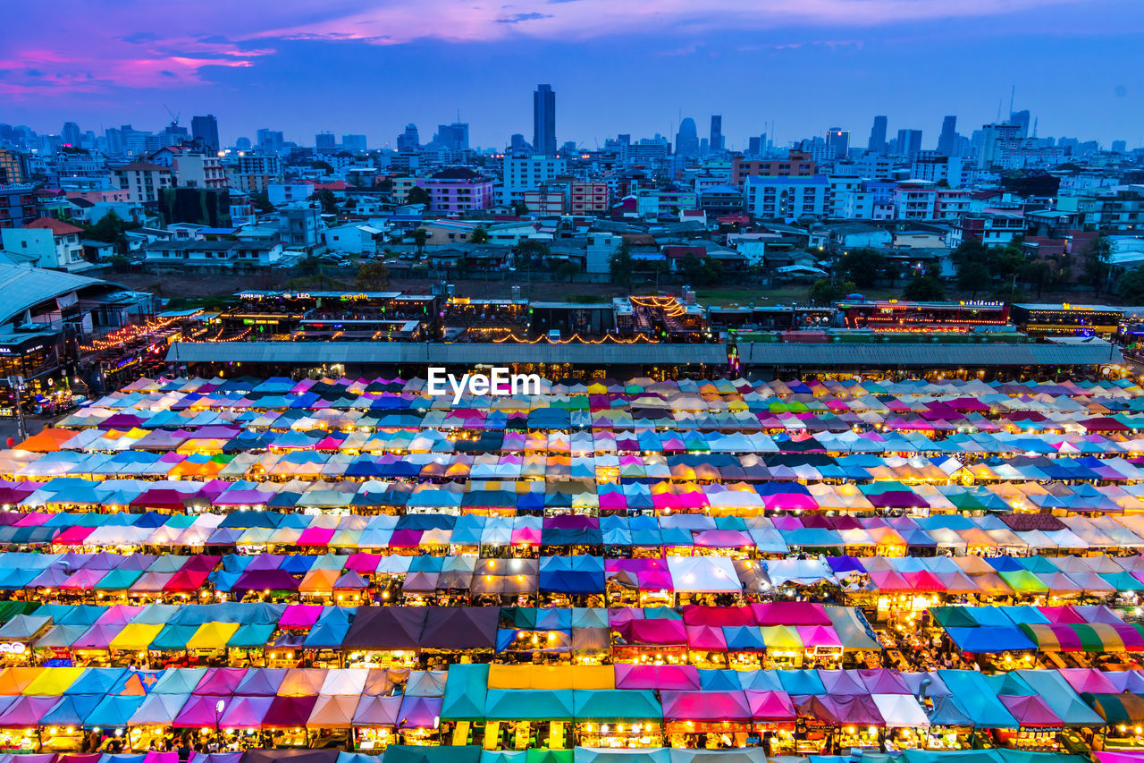 Illuminated market in city at dusk