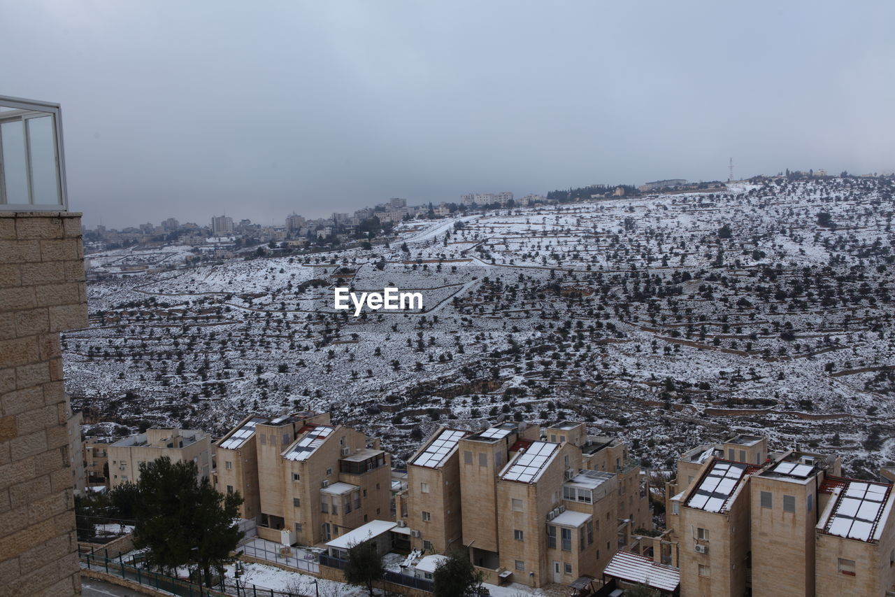 architecture, snow, winter, building exterior, built structure, cold temperature, building, city, sky, nature, environment, cityscape, no people, residential district, urban area, high angle view, house, landscape, outdoors, travel destinations, land, town, day, scenics - nature, residential area, roof, travel