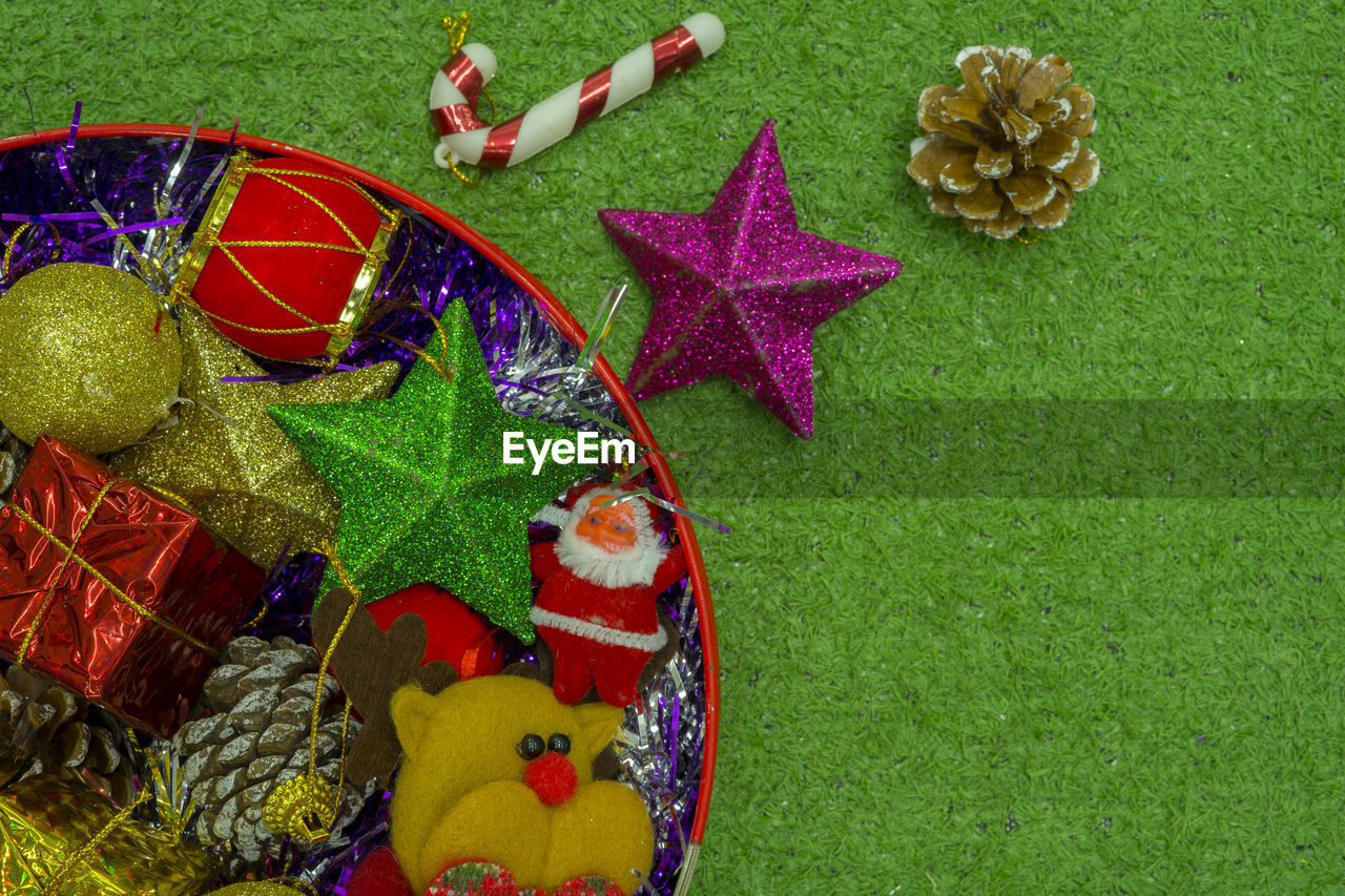 HIGH ANGLE VIEW OF MULTI COLORED UMBRELLAS ON GREEN BACKGROUND