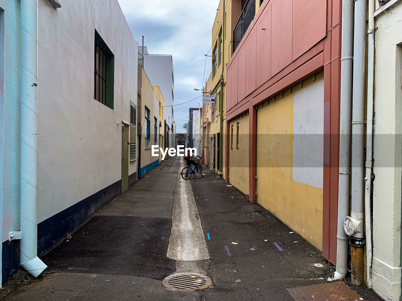 Cyclist riding down the backstreets of napier amidst buildings in city