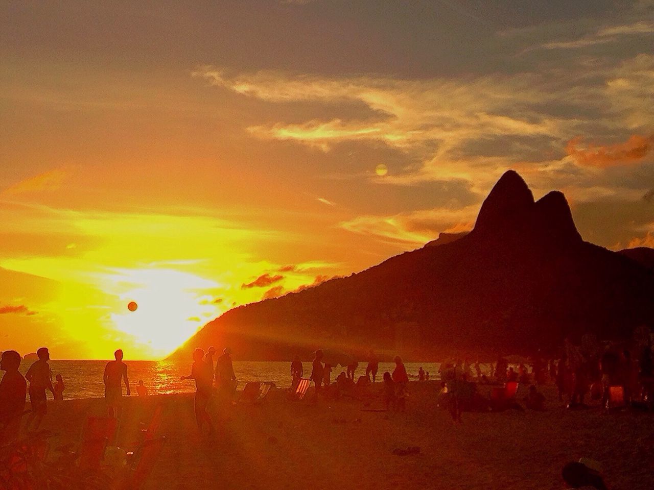 Silhouette people on beach at sunset