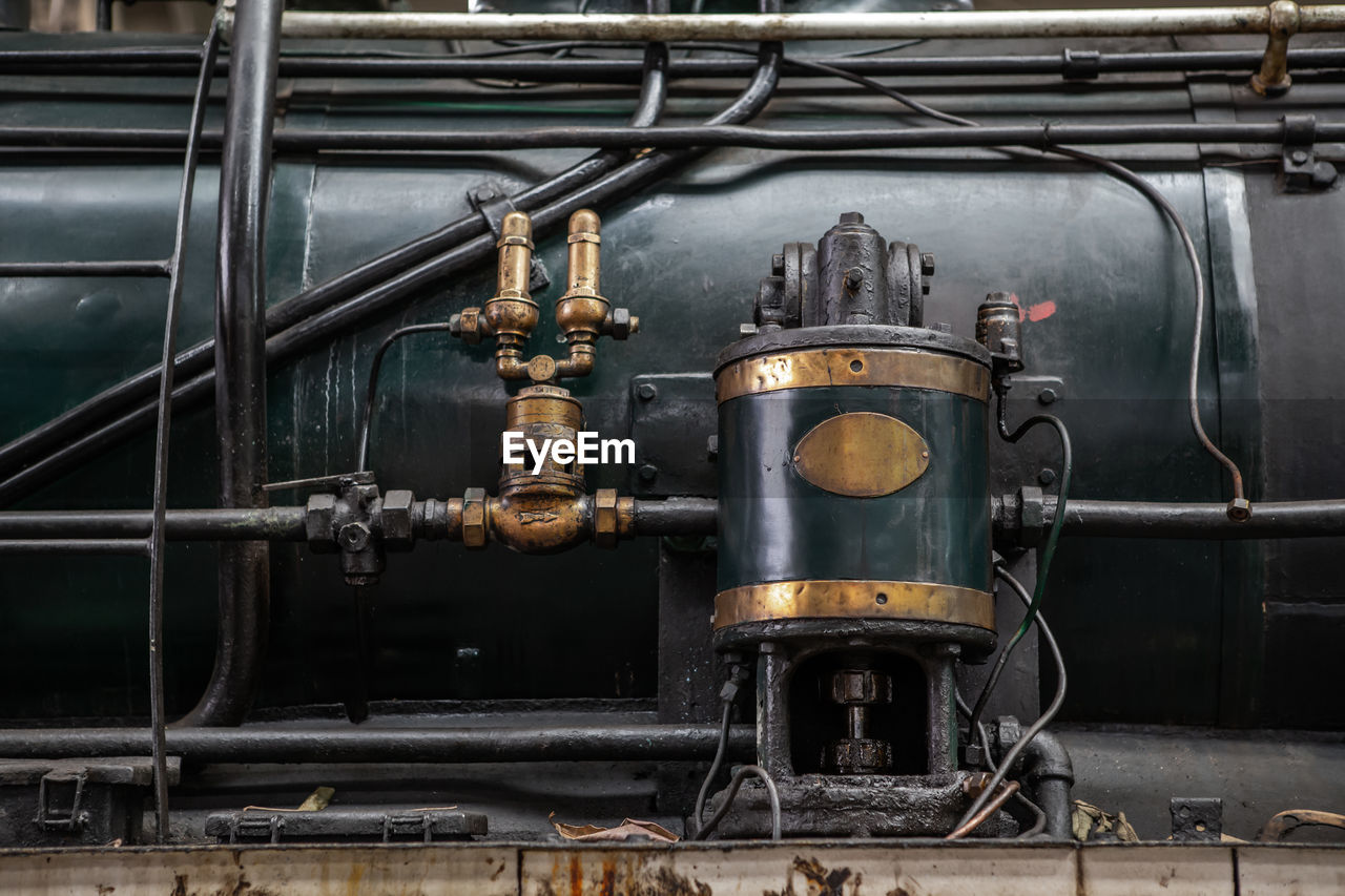 A long-used metal device filled with oil stains is mounted on a steam locomotive