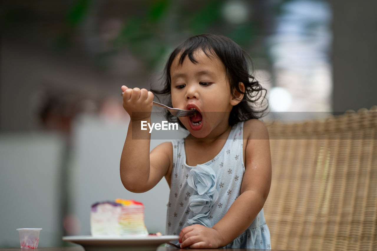 Cute girl eating food at home