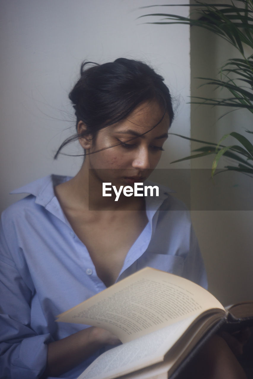 Young woman sitting on book