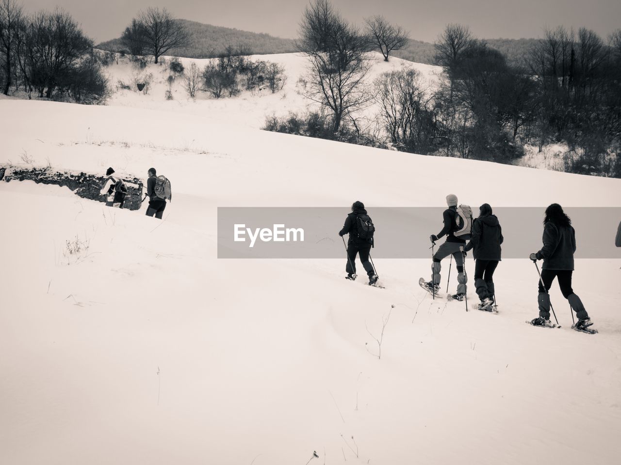 PEOPLE ON SNOWCAPPED LANDSCAPE AGAINST SKY