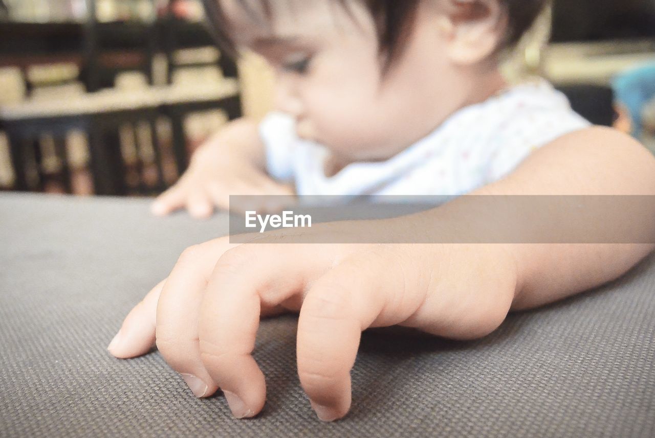 Close-up of cute baby hand on sofa