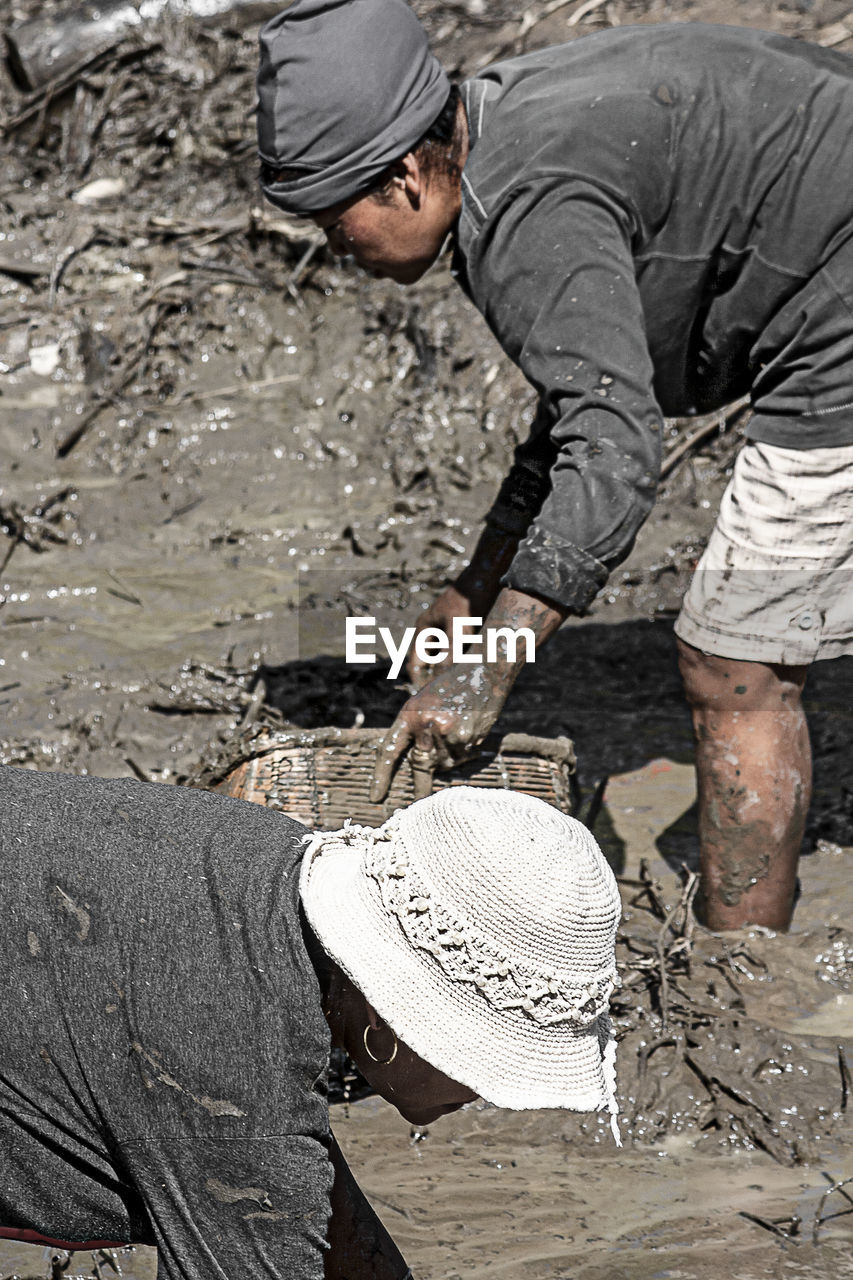 REAR VIEW OF MAN WORKING ON LAND