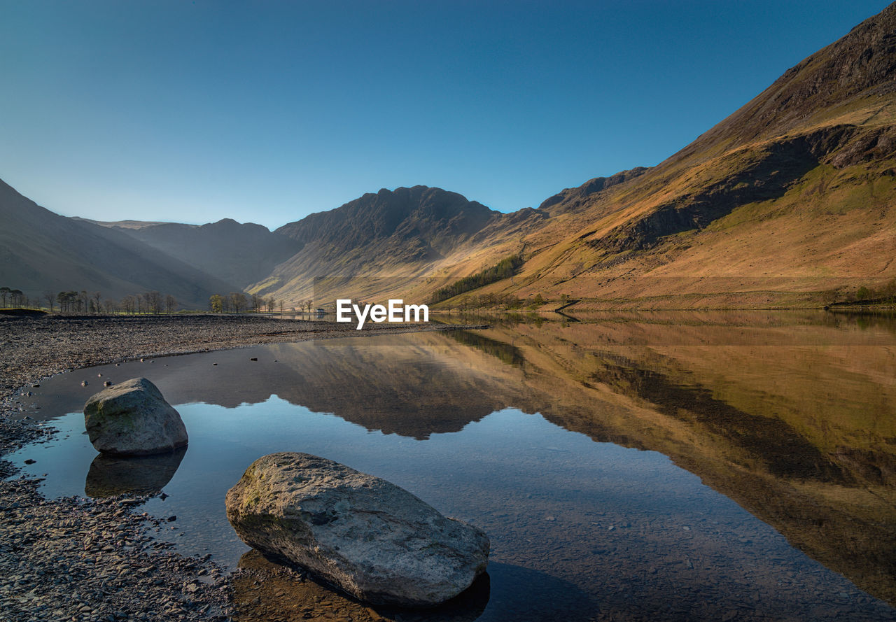 Scenic view of lake and mountains against clear sky