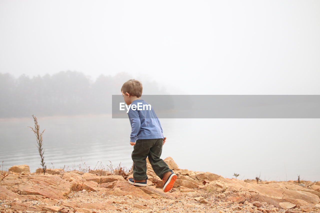 Boy walking at sea shore