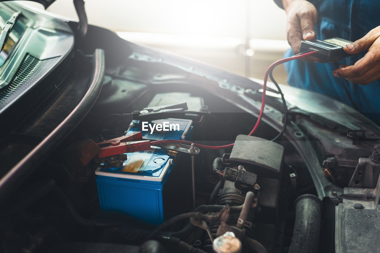 midsection of man working in car