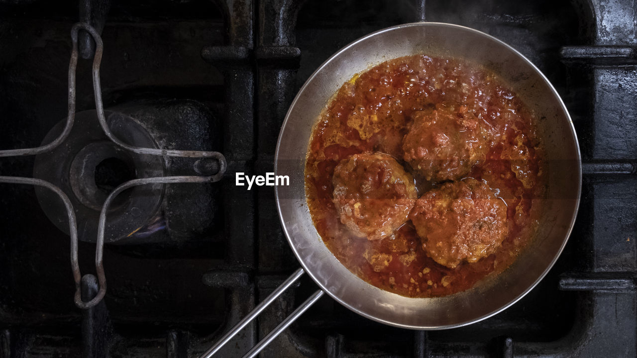 Cooking meatballs on stove. in a restaurant kitchen.