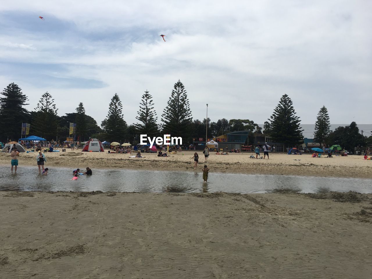 PEOPLE ENJOYING ON BEACH AGAINST SKY