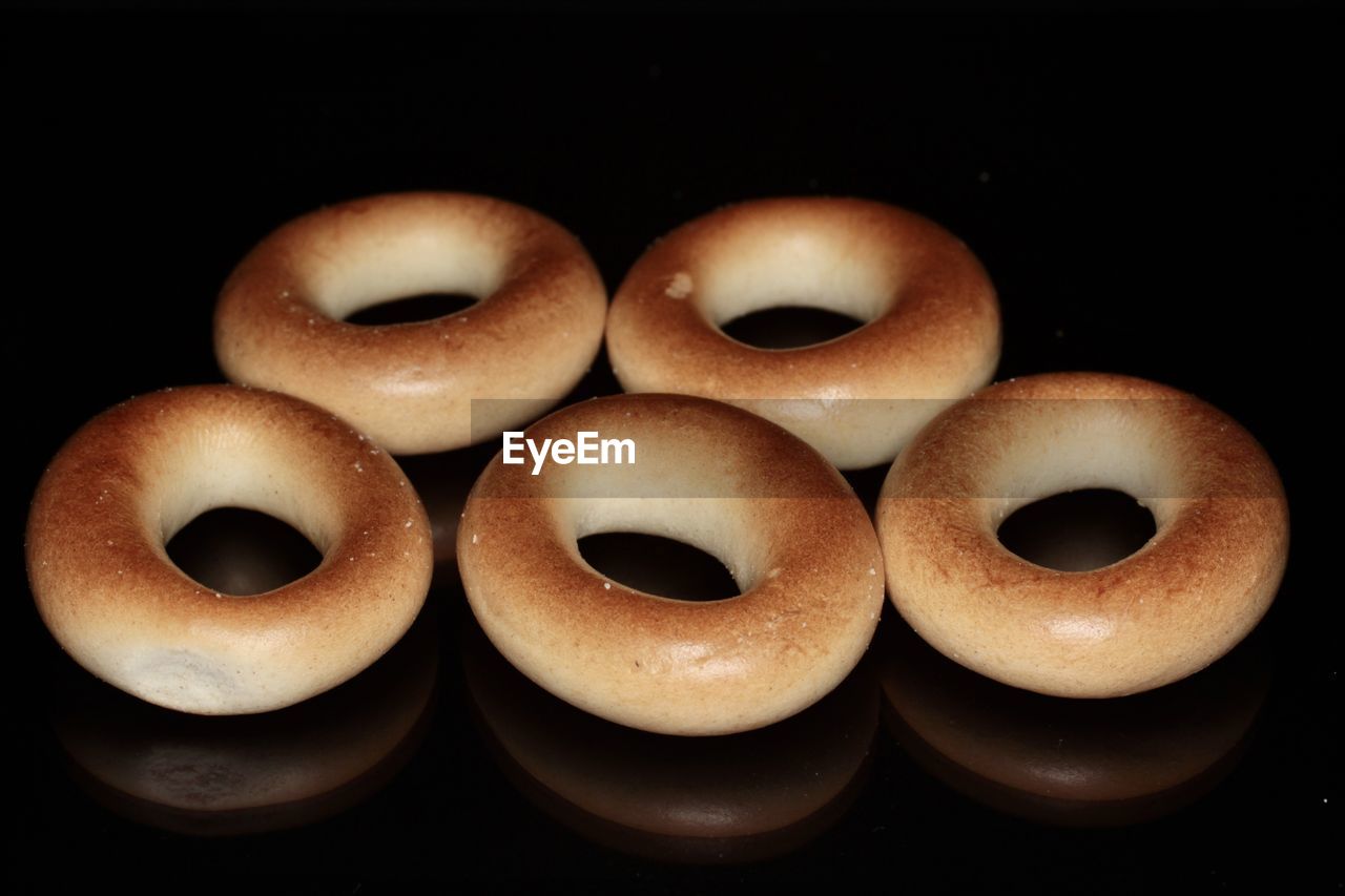 black background, food, food and drink, baked, studio shot, indoors, no people, dessert, doughnut, close-up, freshness, sweet food, snack, still life, group of objects, sweet