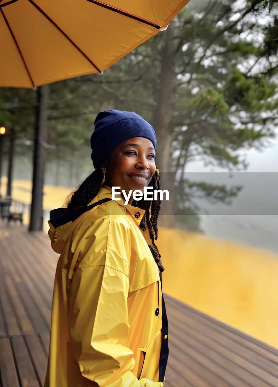 portrait of young woman with umbrella standing on street