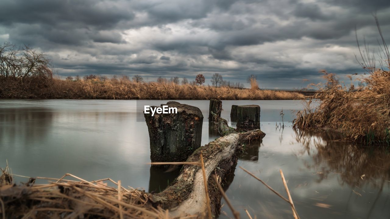 nature, reflection, water, cloud, sky, morning, river, winter, plant, landscape, tree, environment, no people, beauty in nature, scenics - nature, wetland, tranquility, shore, overcast, storm, wilderness, outdoors, autumn, architecture, tranquil scene, day, storm cloud, rural area, dramatic sky, travel destinations, wood