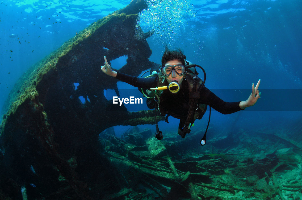 A woman doing scuba diving near a shipwreck