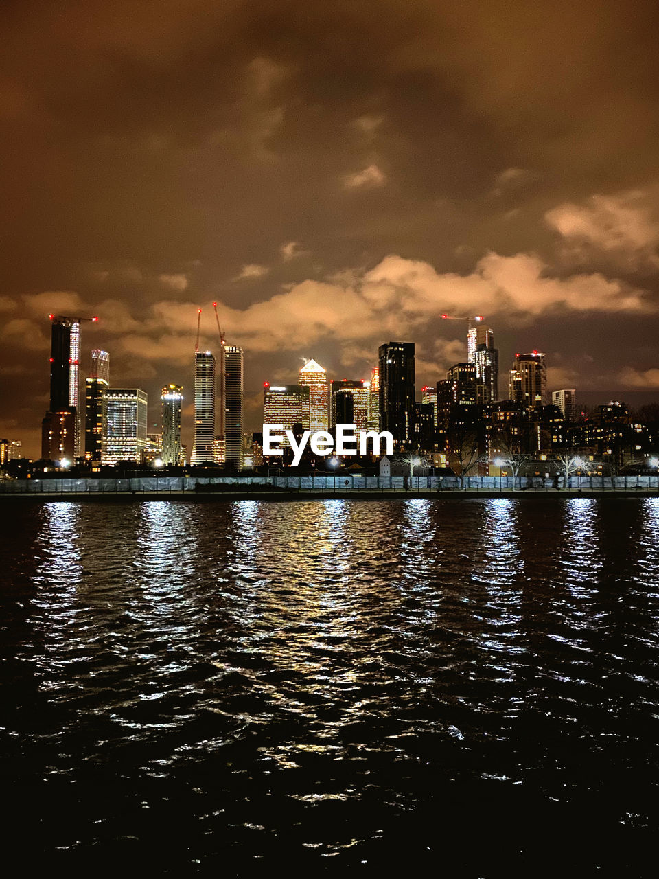 RIVER BY ILLUMINATED BUILDINGS AGAINST SKY IN CITY