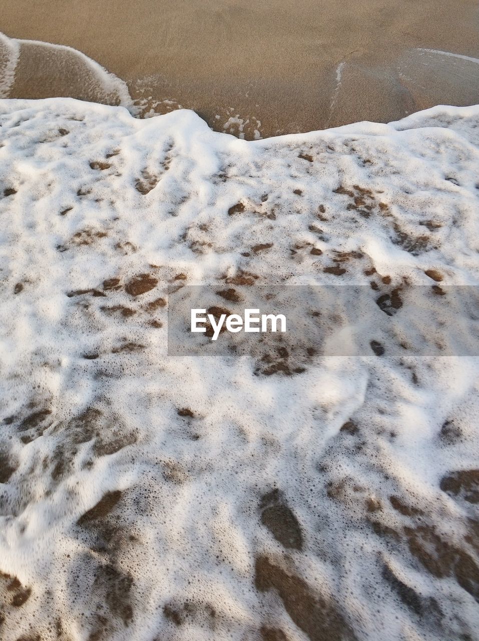 HIGH ANGLE VIEW OF BUBBLES ON BEACH