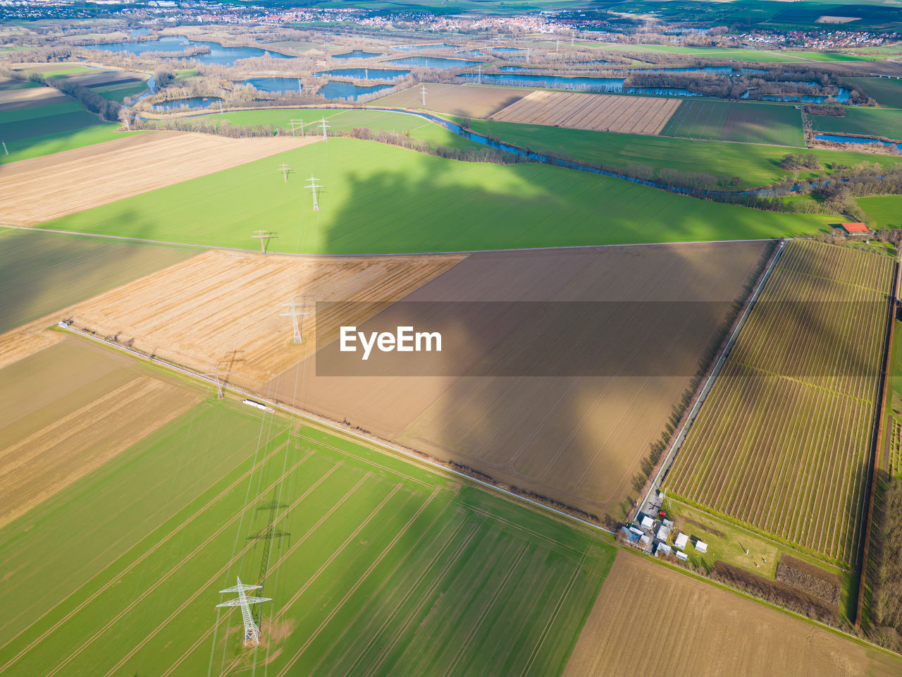landscape, environment, agriculture, aerial view, field, rural scene, land, plain, farm, aerial photography, scenics - nature, nature, green, beauty in nature, high angle view, plant, outdoors, patchwork landscape, sports, transportation, no people, sport venue, day, race track, crop, tranquil scene, tranquility, growth, bird's-eye view, polder, stadium, water, sky, grass, summer, idyllic, architecture, non-urban scene, sunlight, rural area, travel