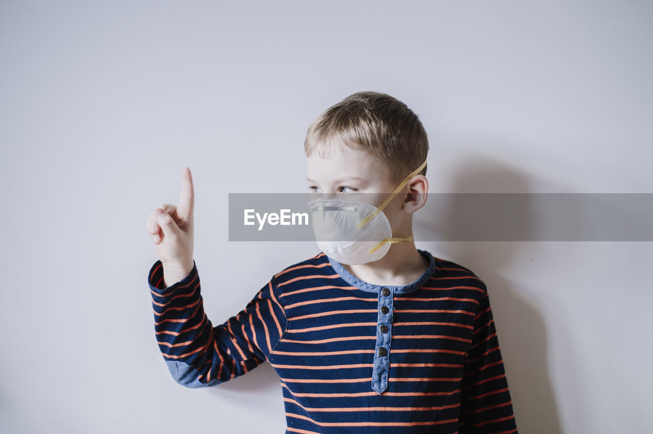 Portrait of boy standing against white background