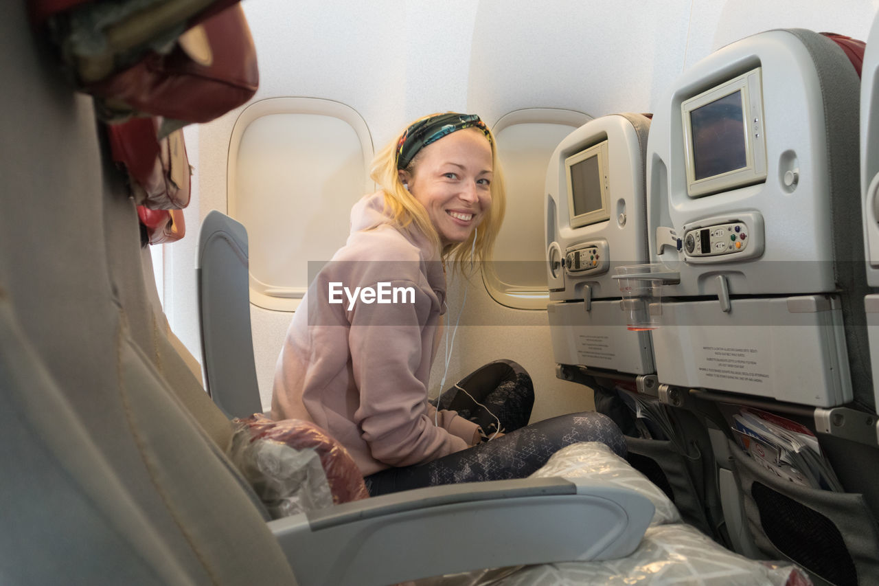 Portrait of smiling woman sitting in airplane