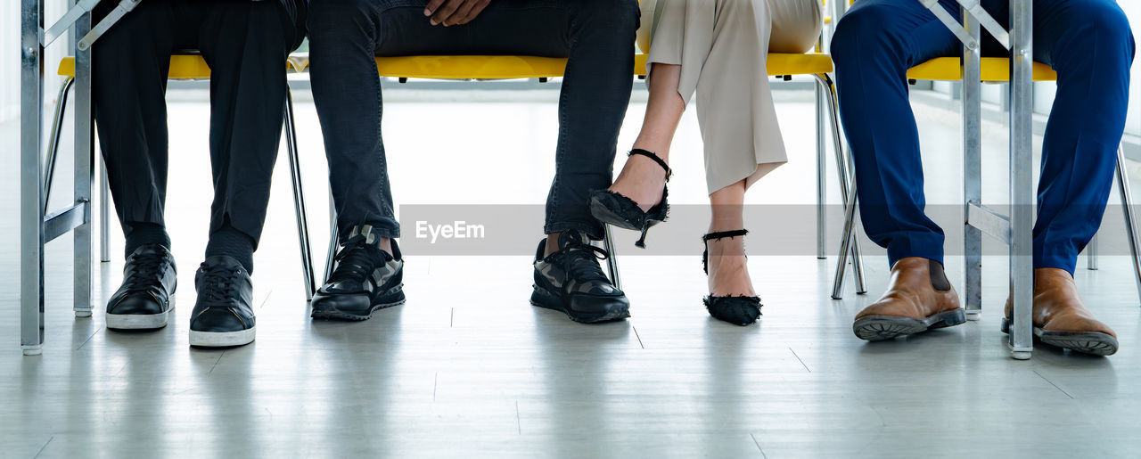 A group of people sitting at a table with their feet on the floor. scene is casual and relaxed