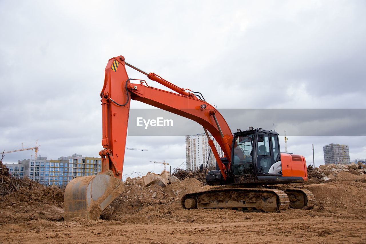 Red excavator during earthmoving at construction site. backhoe dig ground for the construction 