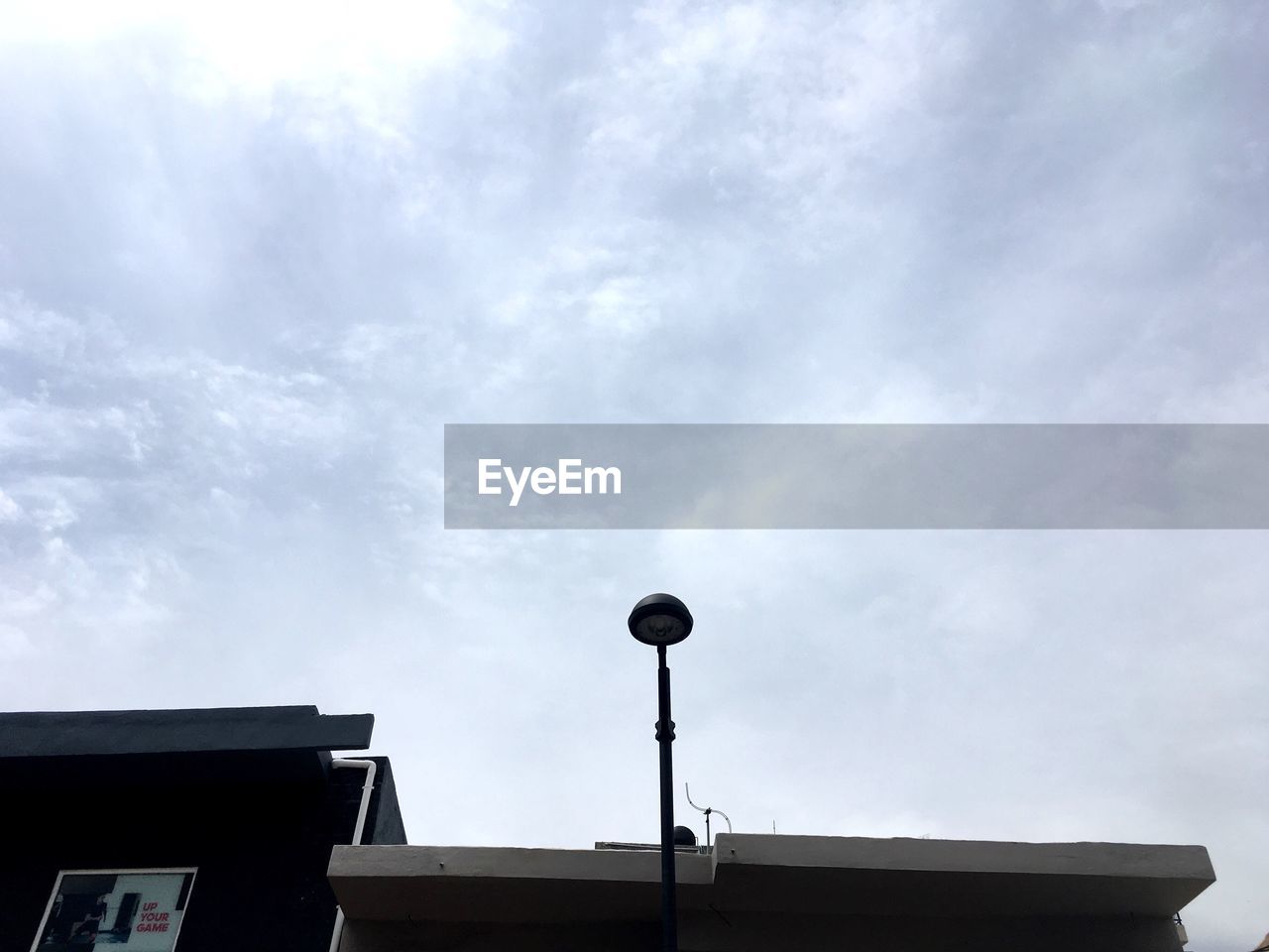 LOW ANGLE VIEW OF ROOF AGAINST CLOUDY SKY