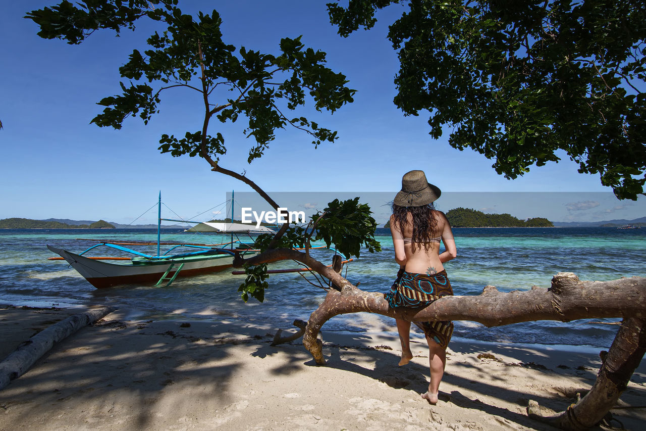 REAR VIEW OF MAN ON BEACH