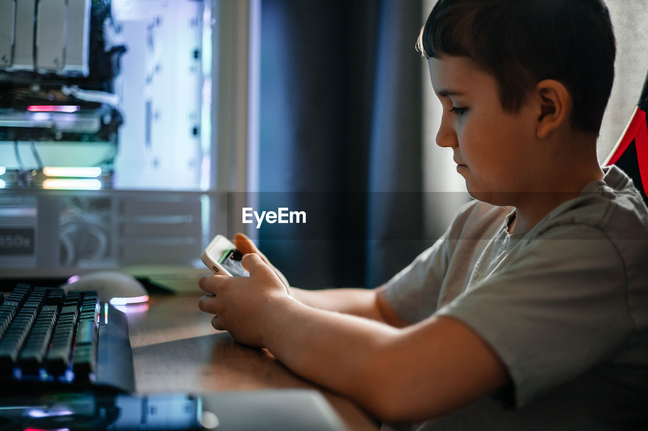 side view of boy using laptop