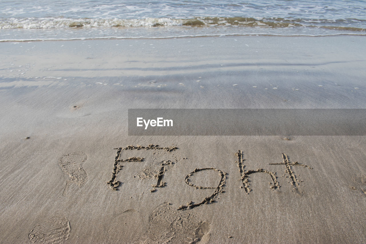 High angle view of text on sand at beach