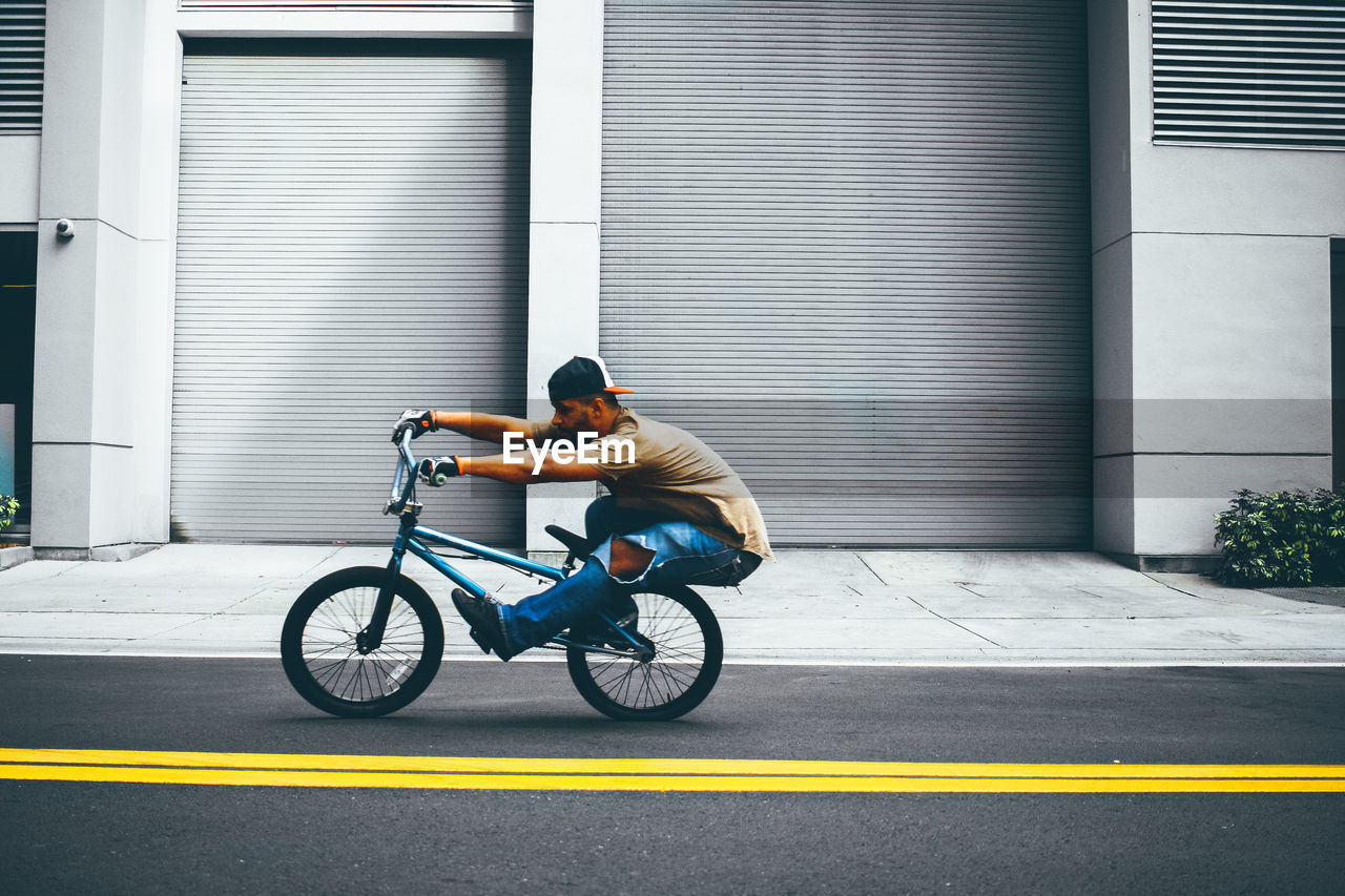 MAN RIDING BICYCLE ON ROAD